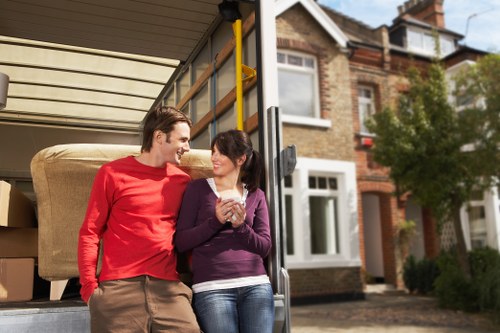 Professional movers carrying household items during an Isleworth move
